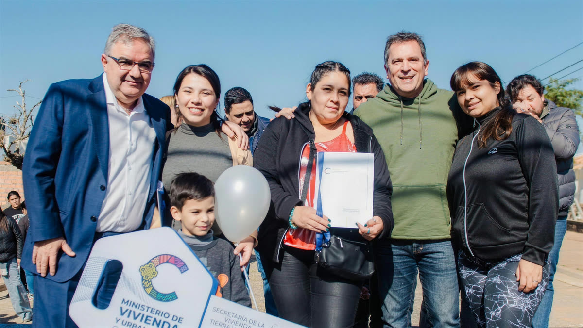 El gobernador Raúl Jalil y el Ministro Dr. Fidel Sáenz junto a una familia que recibe su vivienda en el Loteo Parque Sur, con la llave del Ministerio de Vivienda y Urbanización.